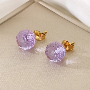 Macro shot of faceted purple crystal stud earring with gold metal base and sparkling facets