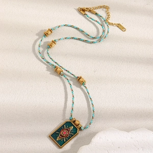 Macro shot of 18K gold plated evil eye pendant with green enamel on a blue braided cord
