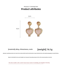 Detail view of vintage gold heart earrings with pink resin, crystals, 4cm x 2cm size