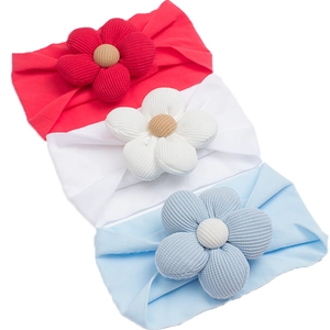 Close-up of soft nylon baby headbands with large fabric flowers in red, white and blue