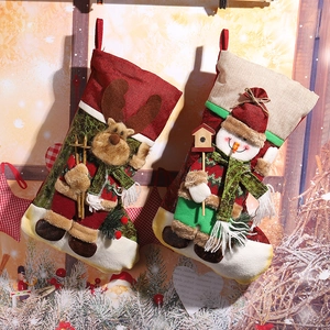 Close-up of festive linen Christmas stockings with 3D reindeer and snowman designs