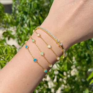 Detail of S925 sterling silver gold bracelets with Mobius design and opal stones