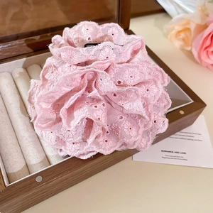 Gros plan détaillé d'une pince à cheveux rose en dentelle dans un écrin en bois
