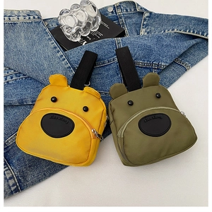 Close-up of yellow and green cartoon puppy handbags with a 3D ear design on denim