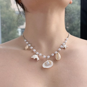 Detail of beaded sea shell necklace featuring pearls and starfish pendant for women