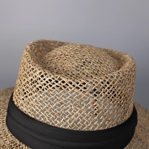 Wide brim woven straw sun hat with black ribbon detail for beach travel and sun protection