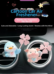 Close-up of cute penguin and pig car air fresheners on a circular air vent outlet