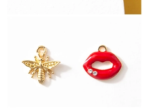 Detailed view of bee and red lip alloy pendants with rhinestones for DIY jewelry making