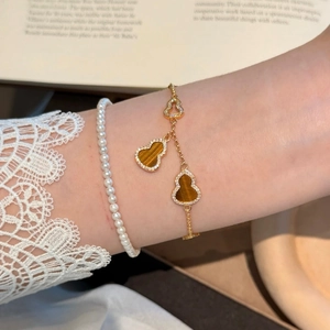 Bracelet hulu en plaqué or 18 carats avec pierre œil de tigre et breloque évidée