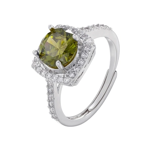 Macro detail of silver ring with round olive green gemstone and pavé halo setting