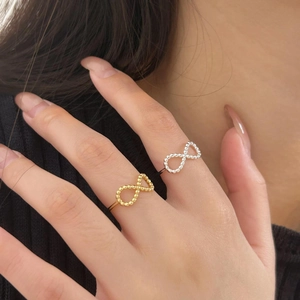 Detail of silver and gold infinity rings with bead texture on model hand