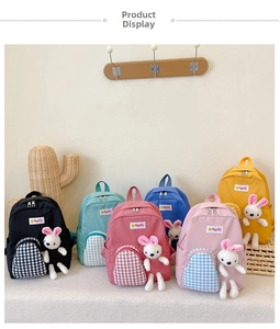 Detail view of colorful children backpacks with checkered pockets and plush bunny charms