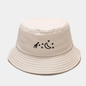 Close-up of beige cotton bucket hat with black moon and star embroidery detail