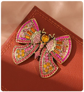Macro shot of luxury butterfly brooch with colorful crystals on leather background