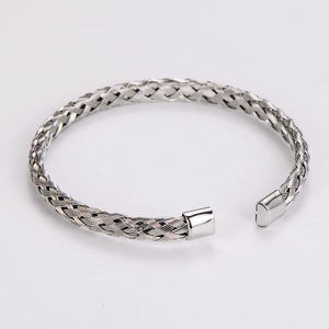 Macro view of silver handmade braided twist open bangle with intricate woven texture detail