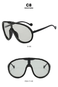Close-up of oversized black sunglasses featuring side and front views with rhinestone details