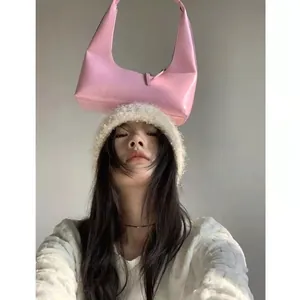 Close-up of pink patent leather hobo bag and plush cream faux fur bucket hat detail