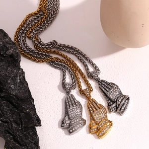 Detailed view of hip hop prayer hand pendants in gold silver and black with cubic zirconia