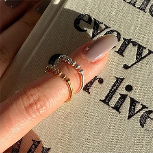 Close-up of minimalist beaded 925 sterling silver rings in gold and silver finish