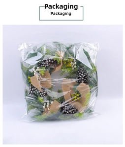 Christmas pine needle wreath with pine cones and berries in clear protective packaging