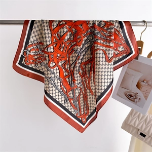 Detailed close-up of a high-quality silk square scarf with horse harness pattern on a hanger