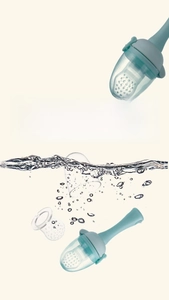 Detail of baby fruit feeder being rinsed in water showing its detachable silicone parts