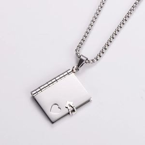 Macro detail of silver stainless steel book locket with heart cutout and mirror finish