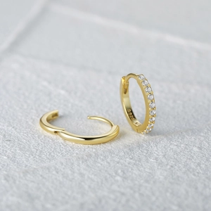 Macro shot of S925 sterling silver gold wavy earrings with sparkling zircon inlay