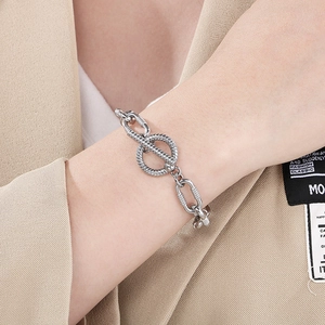 Close-up of industrial silver 10mm chain bracelet with textured toggle clasp on wrist
