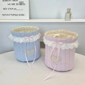 Detail of quilted striped fabric organizers with heart lace trim and pink ribbon bows