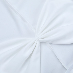 Detailed close-up of white dress with twisted knot design and pleated fabric texture