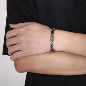 Gros plan détaillé d'un bracelet byzantin pour homme en acier titane sur le poignet d'un modèle