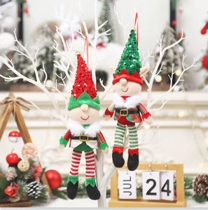Close-up of red and green sequined Christmas elf dolls hanging on white tree branches