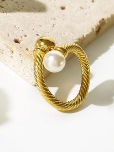 Detailed macro of 18K gold titanium ring featuring twisted texture and white pearl accents