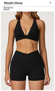 Detail of high-waist crisscross shorts with side pockets and V-neck sports bra in matte black
