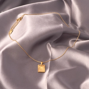 18k gold plated stainless steel necklace with rectangular sun relief pendant on silk