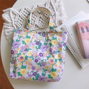 Détail d'un sac à main en coton floral avec étiquette 'Simple Wish' sur un bureau