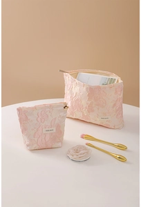 Close-up of pink embossed floral fabric makeup bags with flower metal zippers