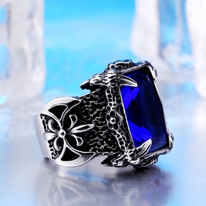 Macro detail of gothic signet ring with deep blue gemstone and carved floral pattern