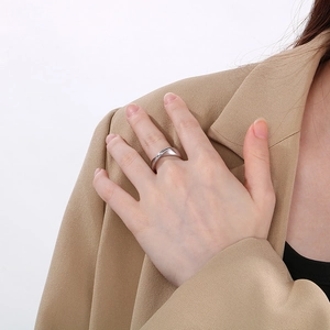 Close-up of a minimalist irregular silver stainless steel ring worn on a finger