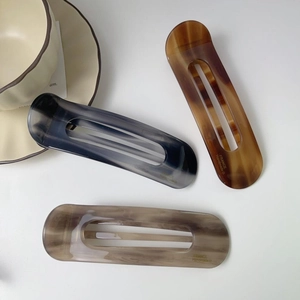 Detail showing high-quality acetate hair clips with marble texture and handmade engraving