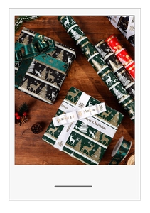 Detail of vintage Christmas wrapping paper rolls with Merry Christmas ribbons on wood