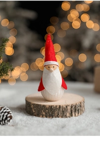 Detail of Christmas scavenger doll on wooden base with festive snow background