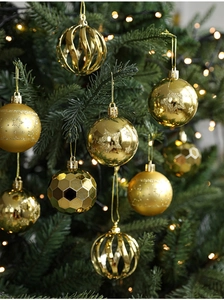 Detail of assorted gold Christmas ornaments with glitter and star patterns on tree