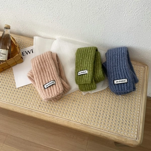 Detail of soft chunky knit ribbed scarf with KN STUDIO tag in pink, green and blue