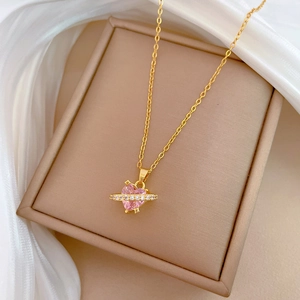 Detail of pink heart gemstone necklace with crystal ring on silk background