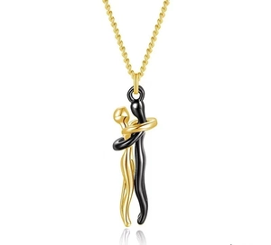 Close-up of gold and black hugging couple pendant with polished metal finish and fine chain