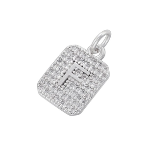 Macro detail of silver square pendant with letter F and cubic zirconia setting