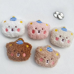 Detailed view of five plush bear brooches in various colors with metal pins