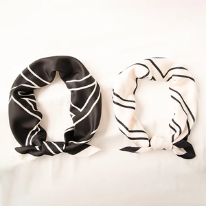 Elegant black and white geometric silk scarves set on a clean white background